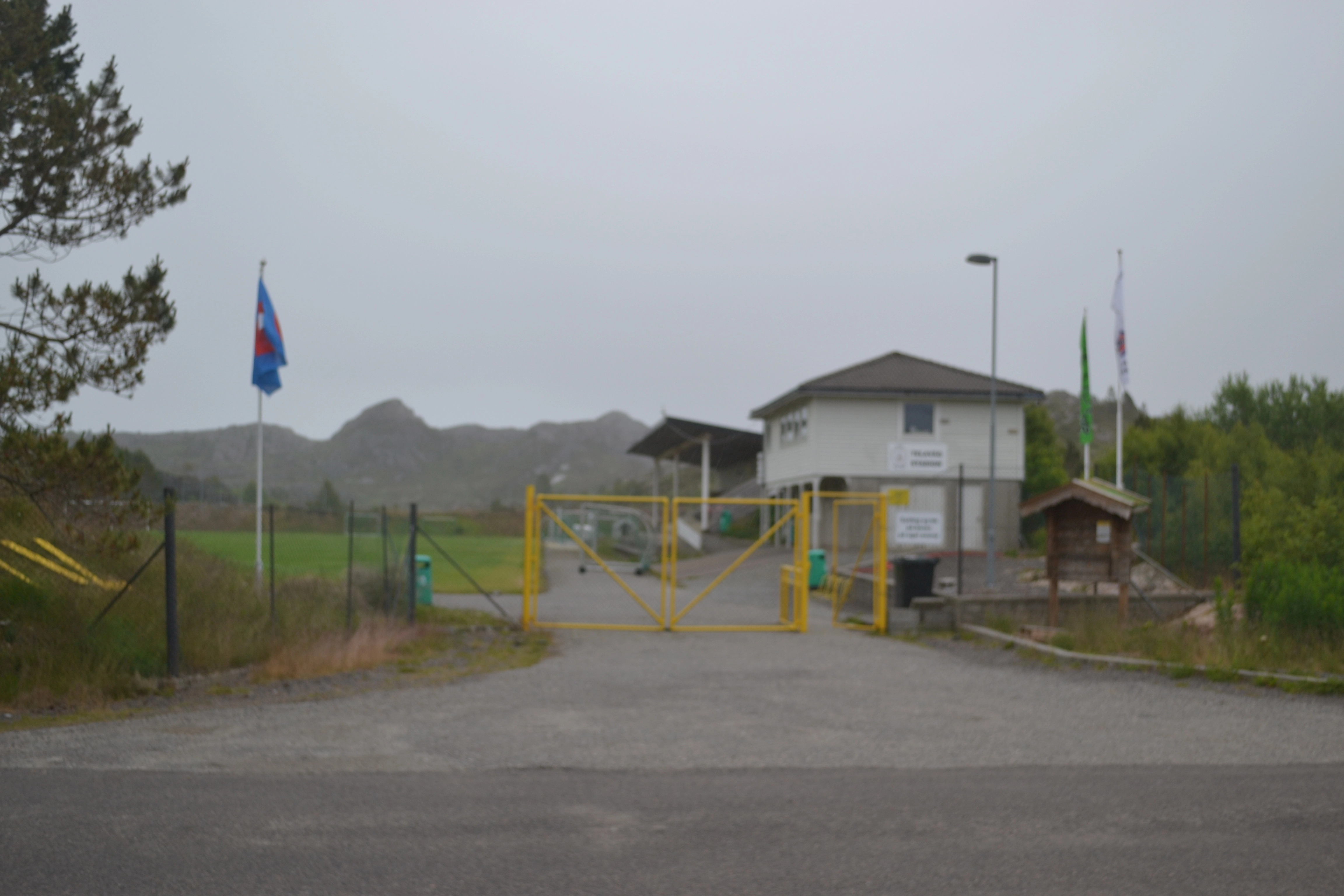 bilde av porten in til stadioen, man kan se gressbanen og tribunen i bakgrunnen